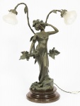 ALLIOT, Lucien Charles Edouard (1877- 1942)- "Figura feminina e ramos de folhas". Luminária de mesa para 2 luzes de bronze patinado. Assinado. Base de madeira. Mangas de vidro branco fosco (com estalados). Altura total 76,5 cm.