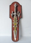 Linda espada decorativa, feita em pesado aço, com suporte em madeira. Peça decorada com figuras de gárgulas e ricos detalhes em relevo. Medidas de 48cm x 12cm (espada) e 54cm x16cm (suporte).