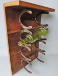 Bela Adega feita em madeira nobre do tipo Peroba Rosa e ferro. possui ferraduras como suportes para as garrafas. Medidas de 54cm x 37cm.