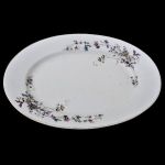 Travessa em porcelana portuguesa `vista alegre` em formato oval com pintura de flores, frutos, pássaros e insetos. Meds: 40,0 cm x 27,5 cm