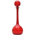 Garrafa em vidro artístico de Murano na cor vermelha em forma de gota, com pescoço longo. Tampa globular. Cerca anos 50 / 60. Alt: 48 cm.