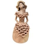 ARTE POPULAR - Escultura de barro cozido representando mulher com vestido de grande guirlanda e arranjo de flores na saia, assinada Noemia, PE Tracunhaem.