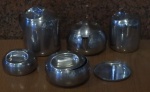 Conjunto com 5 peças em aço inoxidável, sendo uma cremeira, uma manteigueira, um açucareiro, um bula para café e um para água quente para chá.