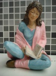 Escultura de leitora com livro em resina policromada com riqueza de detalhes medindo 30 x 20 cm