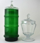 Lote constando de duas "bombonières" em vidro, sendo a maior em tom verde com formato cilíndrico (38 cm)  e a menor incolor (23 cm). Pertencente ao espólio de Sérgio Luiz Viotti e Dorival Carper.