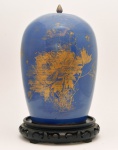 Potiche em porcelana chinesa monocromática decoração `powder blue`, com representações florais em esmaltagem dourada. Século XVIII. Acompanha base em madeira entalhada e fenestrada. 31 cm. 5 cm (base de madeira).