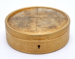 Caixa em bronze `ormollu`, de formato circular, evidenciando tampa, lavrada com motivos românticos. Europa. Transição do século XIX / XX. 4.5 x 13.5 cm.