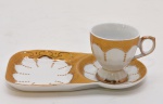 Xícara com pires para bolo, executada em porcelana italiana de superfície branca, decorada com molduras de esmaltagem amarela, enaltecidas em ouro. Itália. Década século XX. 17.5 x 10 cm (pires) 6 x 6 cm (xícara).